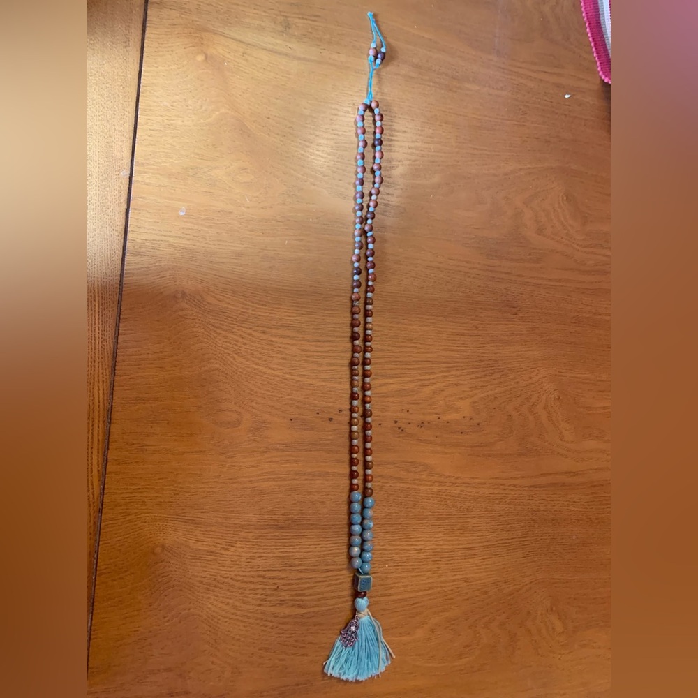 Wood and ceramic beaded necklace with tassel pendant with a Hamsa charm